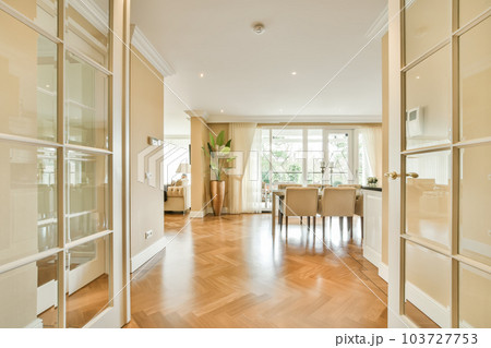 a living room with wood flooring and glass doors leading to the dining area in the room is very clean 103727753
