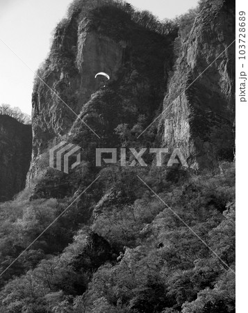 妙義山の岩峰に沿って飛ぶパラグライダー 妙義山の岩峰に沿って飛ぶパラグライダー 103728689