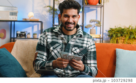 Rich indian man counting money cash and use calculator, calculate domestic income earnings at home 103729298