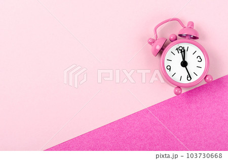 A Vintage pink color alarm clock on pink background. 103730668