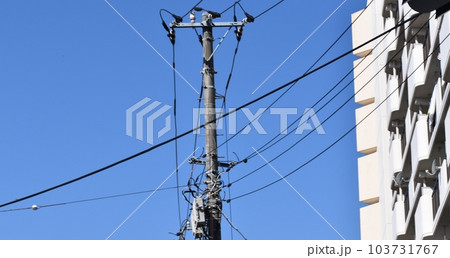 様々なケーブルや電線とそれらを支える電柱 103731767