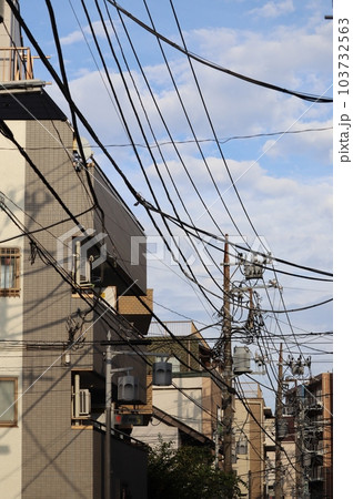 様々なケーブルや電線とそれらを支える電柱 様々なケーブルや電線とそれらを支える電柱 103732563
