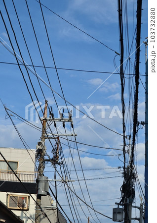 様々なケーブルや電線とそれらを支える電柱 103732880
