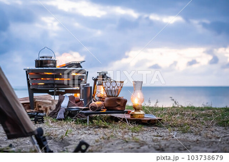 ソロキャンプ 焚き火 焚き火台 野営 キャンプギア ランプ 海 光 灯り ビーチ 水平線 103738679