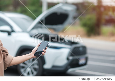 woman driver using mobile phone during problem car. Breakdown or broken car on road. Vehicle Insurance, maintenance and service concept woman driver using mobile phone during problem car. Breakdown or broken car on road. Vehicle Insurance, maintenance and service concept 103739485