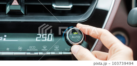 Woman hand adjusting temperature the air flowing during driving car on the road, air conditioner cooling system inside the car. Adjust, temperature and transport concept 103739494