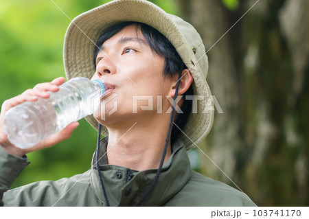 トレッキング中水分補給をする若い男性 103741170