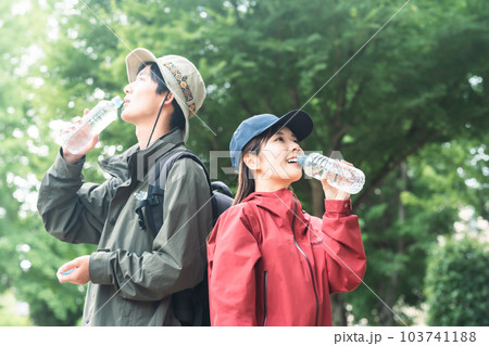 トレッキング中水分補給をするカップル トレッキング中水分補給をするカップル 103741188