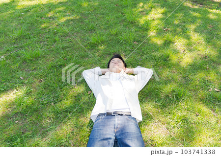 芝生に寝転ぶ男性の写真 103741338