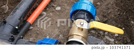 Underground irrigation system with elbow fitting of pvc pipes at bend with yellow tap or faucet 103741371