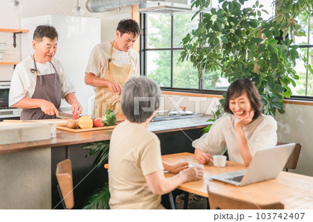 料理をする男性とパソコンを見ながら話す女性(二世帯住宅・三世代家族・シニア・夫婦) 料理をする男性とパソコンを見ながら話す女性(二世帯住宅・三世代家族・シニア・夫婦) 103742407