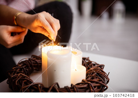 A girl from the fire of a candle standing on a table lights fireworks. A girl from the fire of a candle standing on a table lights fireworks. 103742418