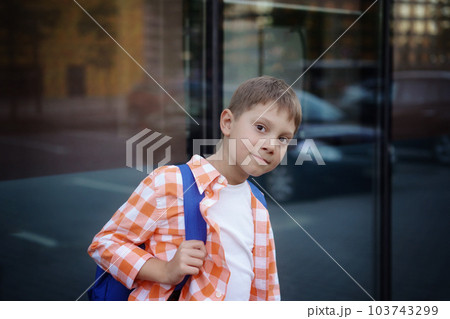 caucasian boy walking from school wearing school bag. Begining of academic year 103743299