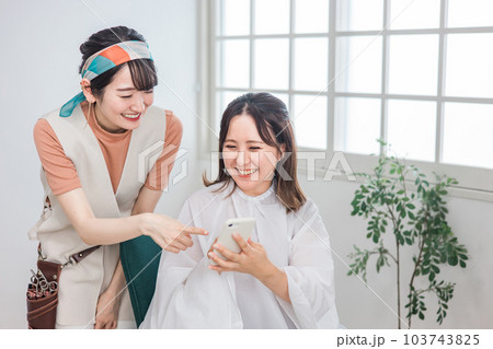 美容室・ヘアサロンで髪型を相談するアジア人女性の客とカウンセリングする美容師・スタイリスト 103743825