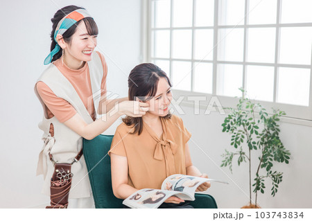 美容室・ヘアサロンで髪型を相談するアジア人女性の客とカウンセリングする美容師・スタイリスト 103743834