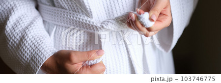 Female hands tying white bath robe closeup 103746775