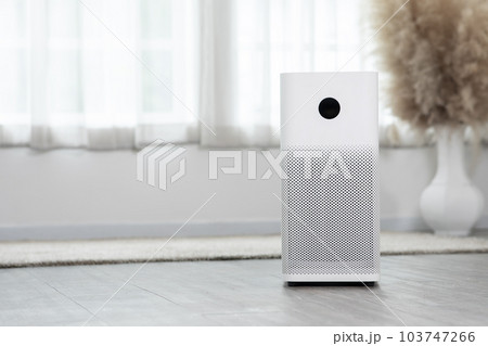 Air purifier in cozy white bedroom for filter and cleaning removing dust PM2.5 HEPA and virus in home,for fresh air and healthy Wellness life.Health care Air Pollution Concept 103747266