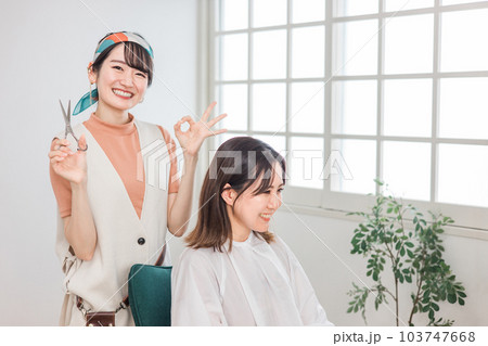 美容室に来た女性と髪を切る・カットする美容師・理容師の女性 103747668