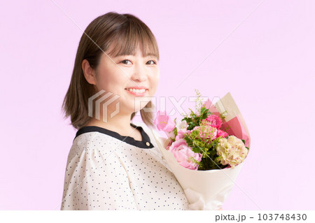 花束を手に持つ笑顔の若い女性 103748430