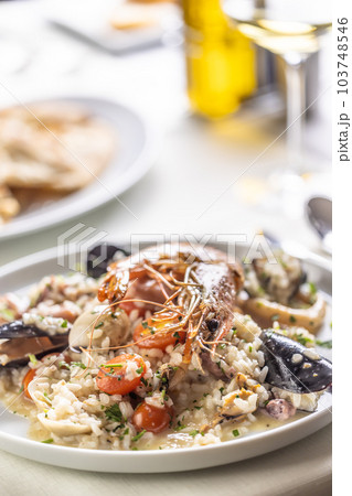 Detail of a seafood risotto made the Italian way and served on a shallow plate Detail of a seafood risotto made the Italian way and served on a shallow plate 103748546