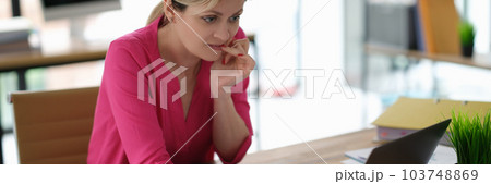 Businesswoman worried and biting her nails in front of laptop screen 103748869