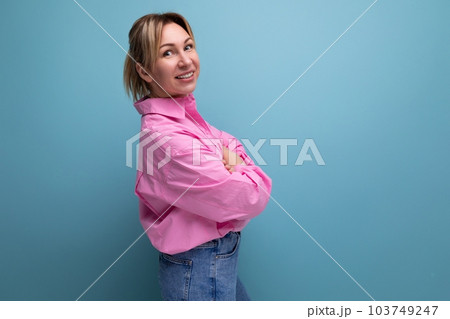 young energetic European blond leader woman with ponytail dressed in a pink blouse on the background 103749247