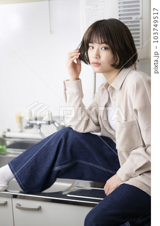 キッチンでポーズをとる若い女性のポートレート 103749517