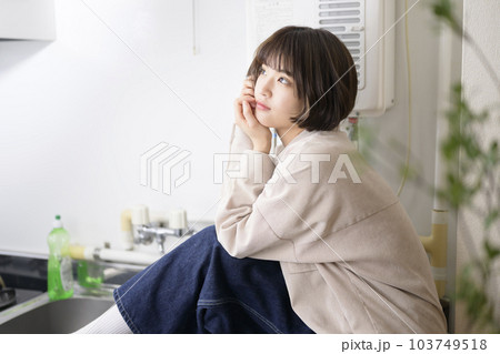 キッチンでポーズをとる若い女性のポートレート 103749518
