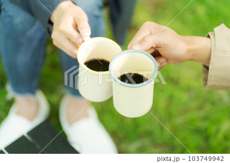 キャンプでコーヒーを飲む男女 103749942
