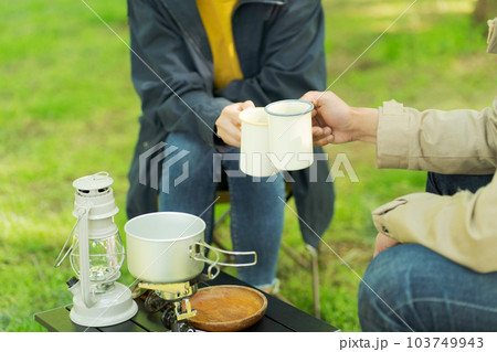 キャンプでコーヒーを飲む男女 103749943