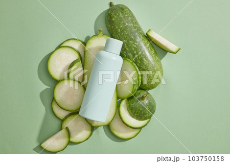 Blank label bottle in pastel color is displayed with a lot of winter melon slices. Mockup of skin care cosmetic tube of beauty facial extracted from Winter melon (Benincasa hispida) 103750158