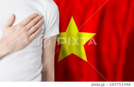 Vietnamese person with hand on heart on the background of Vietnam flag. Patriotism, country Vietnamese person with hand on heart on the background of Vietnam flag. Patriotism, country 103751346