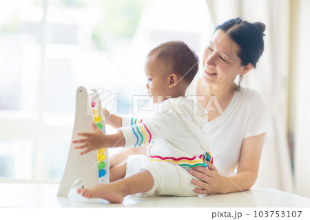 Baby boy playing with wooden abacus. Baby boy playing with wooden abacus. 103753107