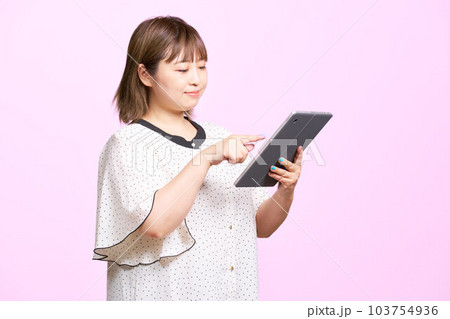 タブレットを使う若い女性 ビジネスカジュアル タブレットを使う若い女性 ビジネスカジュアル 103754936