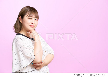 顎を触りながら視線を向ける若い女性 ビジネスカジュアル 顎を触りながら視線を向ける若い女性 ビジネスカジュアル 103754937