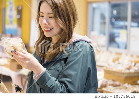 パン屋さんでほしいパンを見つけて喜ぶ若い女性 103756018