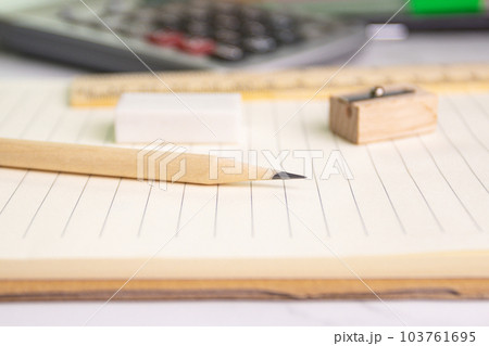 close up a pencil on paper with eraser ruler pencil sharpener on background (selective focus pencil) close up a pencil on paper with eraser ruler pencil sharpener on background (selective focus pencil) 103761695