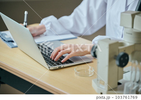 実験データを入力する白衣の若い女性 103761769