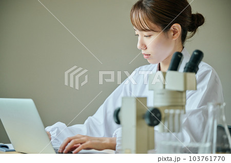 実験データを入力する白衣の若い女性 実験データを入力する白衣の若い女性 103761770