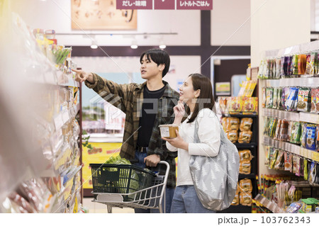 スーパーで買い物をする若い男女 103762343