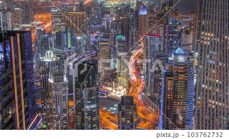 Skyline panoramic view of Dubai Marina showing canal surrounded by skyscrapers along shoreline day to night timelapse. DUBAI, UAE 103762732