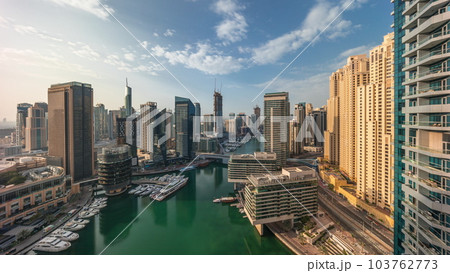 Aerial view to Dubai marina skyscrapers around canal with floating boats timelapse 103762773