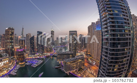 Aerial view to Dubai marina skyscrapers around canal with floating boats day to night timelapse 103762782