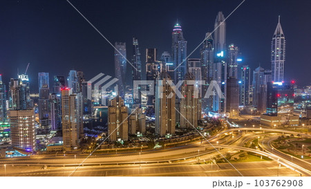 Skyscrapers of Dubai Marina near intersection on Sheikh Zayed Road with highest residential buildings all night timelapse Skyscrapers of Dubai Marina near intersection on Sheikh Zayed Road with highest residential buildings all night timelapse 103762908