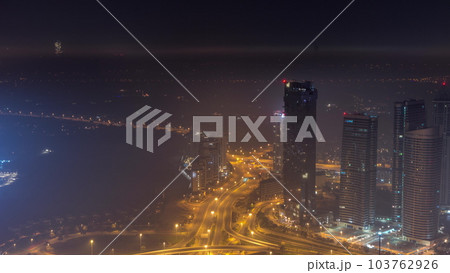 Big crossroad junction between JLT district and Dubai Marina intersected by Sheikh Zayed Road aerial all night timelapse. 103762926