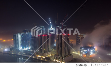 Buildings are covered in thick layer of fog in Business Bay night timelapse. Buildings are covered in thick layer of fog in Business Bay night timelapse. 103762987