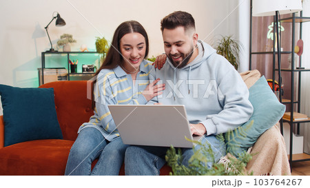 Family couple man woman working on laptop celebrate success win money in lottery, online good news Family couple man woman working on laptop celebrate success win money in lottery, online good news 103764267