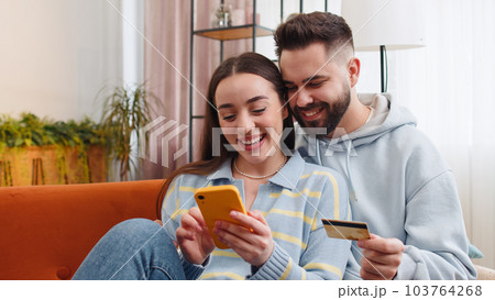 Family married couple using credit bank card smartphone transferring money purchases online shopping Family married couple using credit bank card smartphone transferring money purchases online shopping 103764268