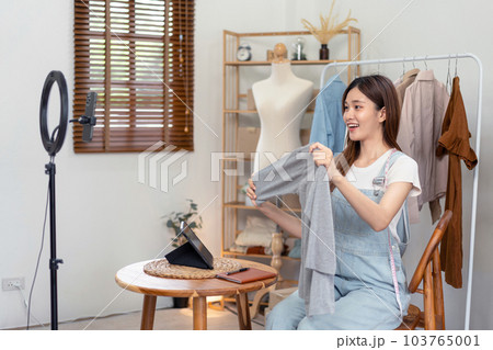 Female online seller is using smartphone to broadcast live on Vl 103765001