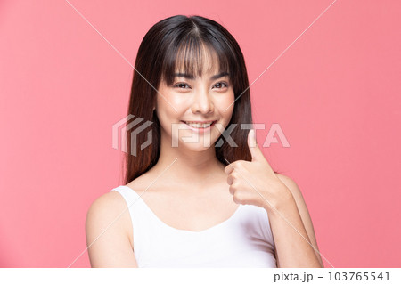 Beautiful Attractive Asian young woman smile and making good sign thumbs up feeling so happiness and confident,Isolated on pink background,Beauty Concept Beautiful Attractive Asian young woman smile and making good sign thumbs up feeling so happiness and confident,Isolated on pink background,Beauty Concept 103765541